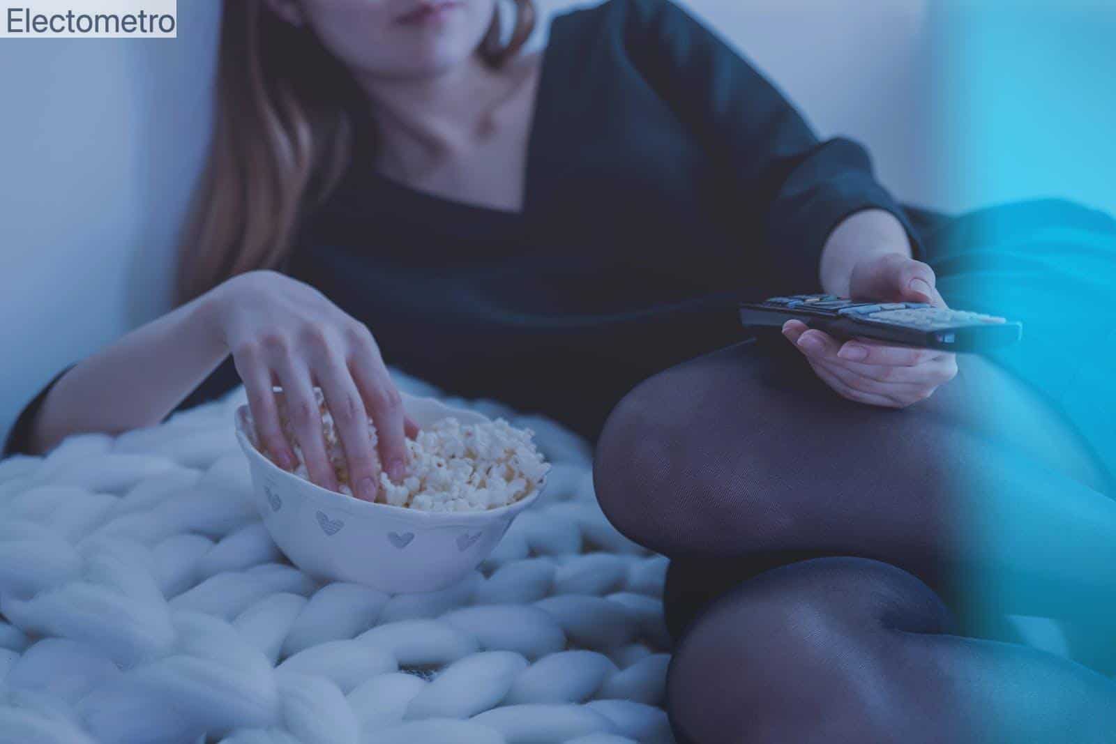 mujer comiendo palomitas con el mando de la tele